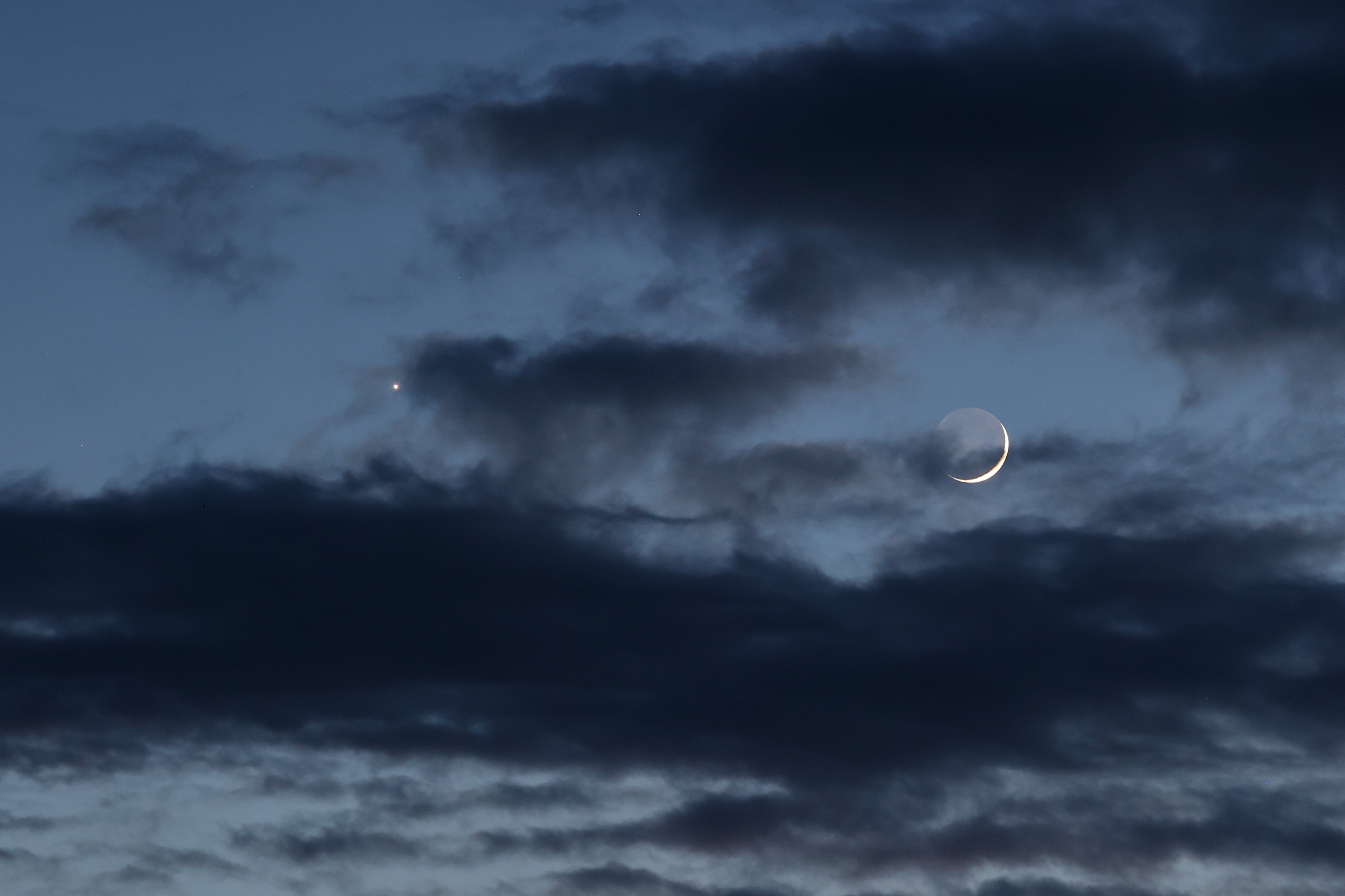 Venus en maan met brekende bewolking